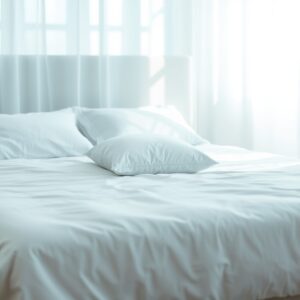 side sleeper pillow guide — A single pillow centered on a neatly made white bed in soft morning light, emphasizing loft and sleep comfort.